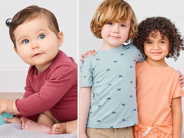 a baby girl with a block in a raspberry body suit and a toddler boy and girl in playwear