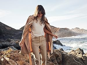 woman walking on the rocks by the water 