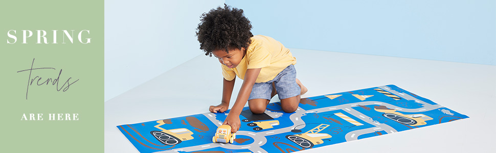 male child playing with toy car on play mat